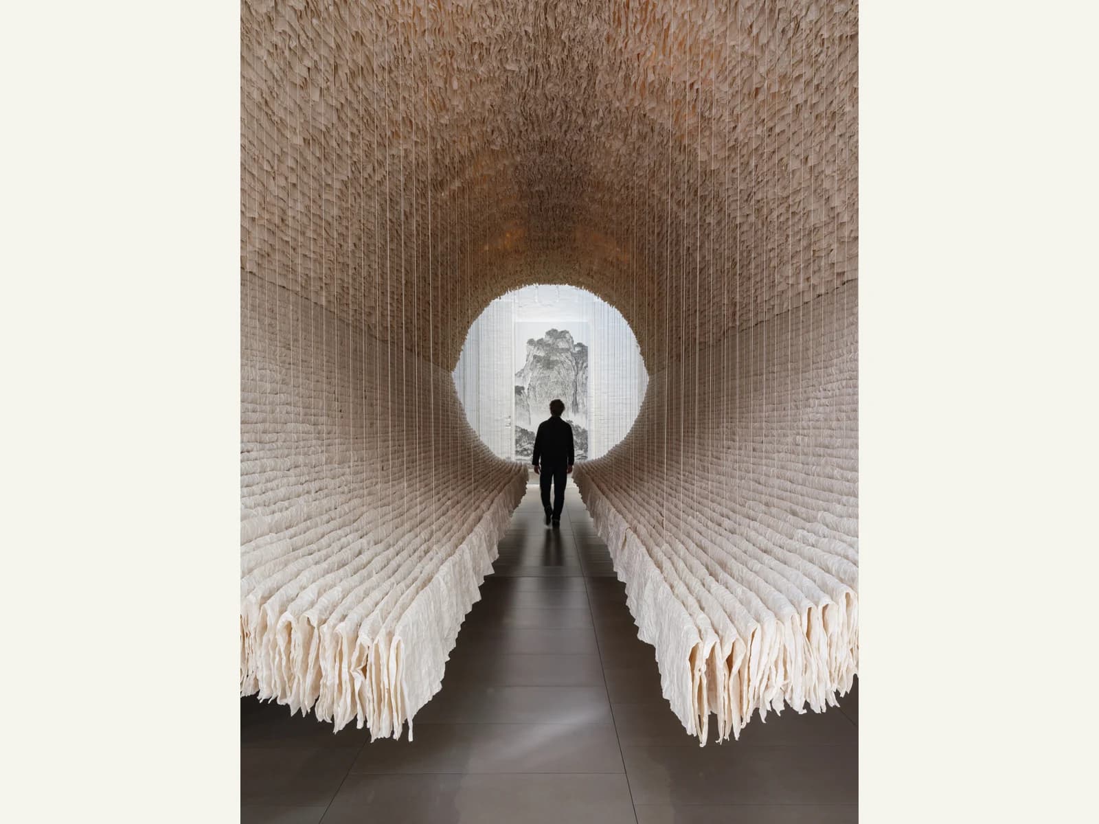 A visitor walking through the suspended paper tunnel of Zhu Jinshi’s The Ship of Time