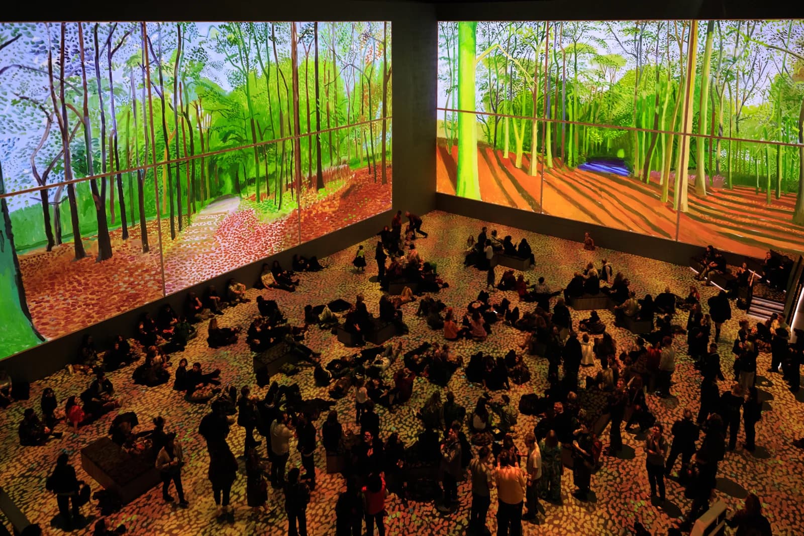 Visitors among large-scale David Hockney projections in a supplied Bigger & Closer exhibition image